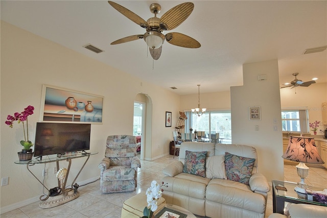 living room featuring a healthy amount of sunlight, ceiling fan with notable chandelier, and light tile patterned floors