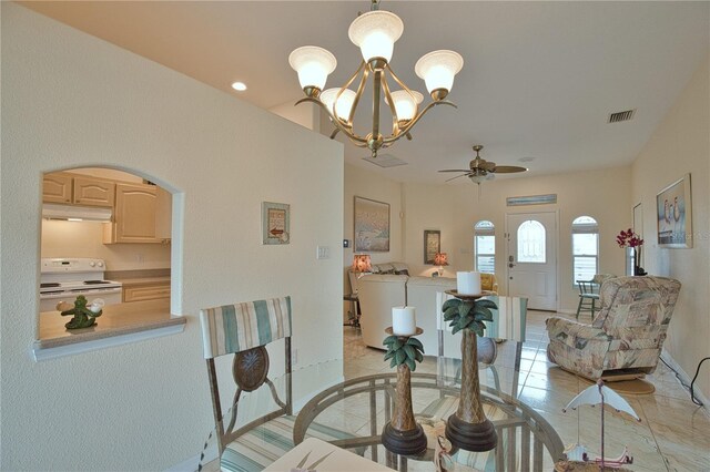 dining area with light tile patterned floors, ceiling fan with notable chandelier, and washing machine and clothes dryer