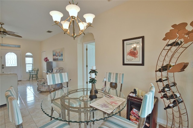 tiled dining room featuring ceiling fan with notable chandelier