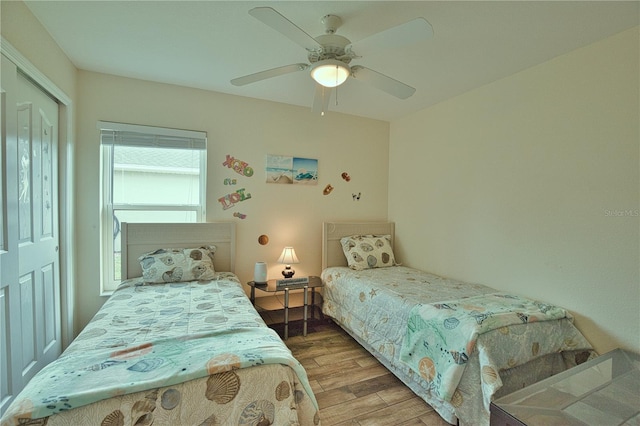 bedroom featuring ceiling fan, wood-type flooring, and a closet