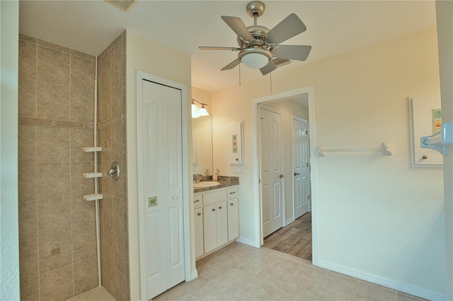 bathroom featuring vanity, a tile shower, and ceiling fan