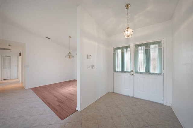 tiled entryway with vaulted ceiling