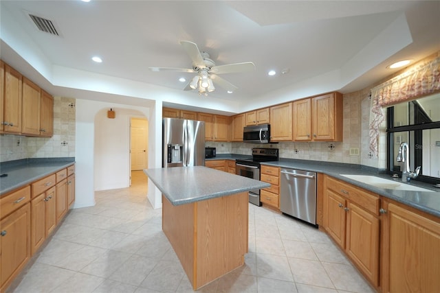 kitchen featuring sink, light tile patterned floors, appliances with stainless steel finishes, tasteful backsplash, and a kitchen island