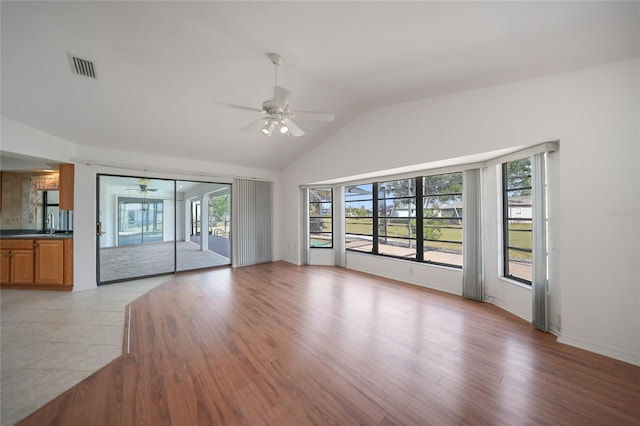 unfurnished living room with a wealth of natural light, ceiling fan, and light hardwood / wood-style flooring