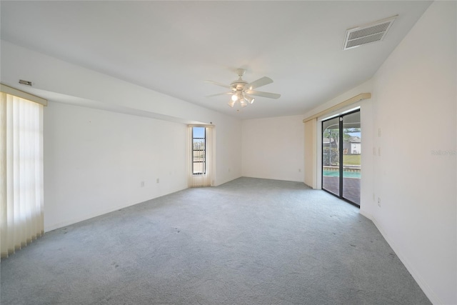 carpeted spare room featuring a wealth of natural light and ceiling fan