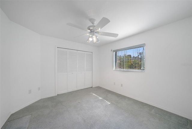 unfurnished bedroom with ceiling fan, carpet flooring, and a closet