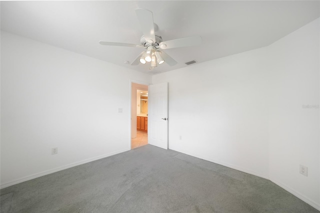 empty room featuring ceiling fan and light colored carpet