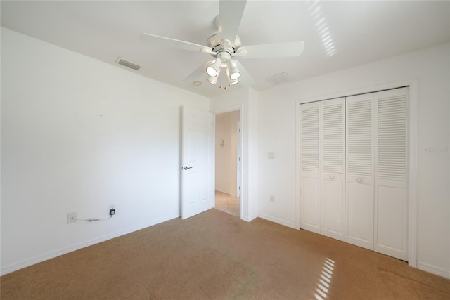 unfurnished bedroom featuring ceiling fan, carpet flooring, and a closet