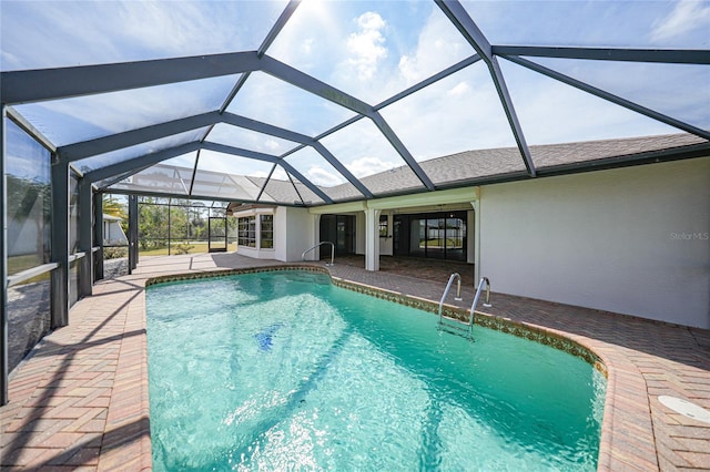 view of swimming pool featuring a patio and glass enclosure