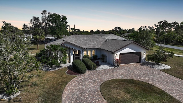 ranch-style house with a garage and a lawn