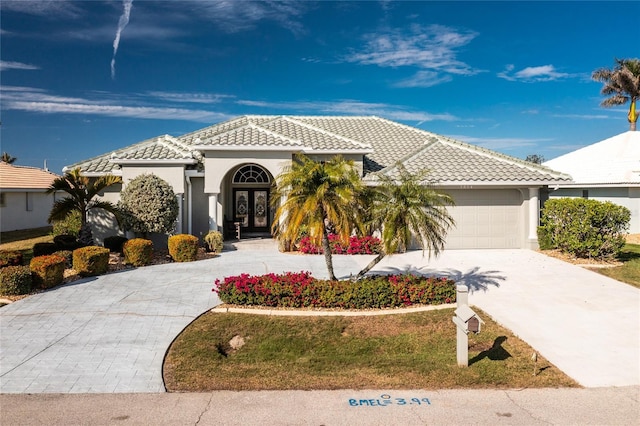 mediterranean / spanish house featuring a garage and french doors