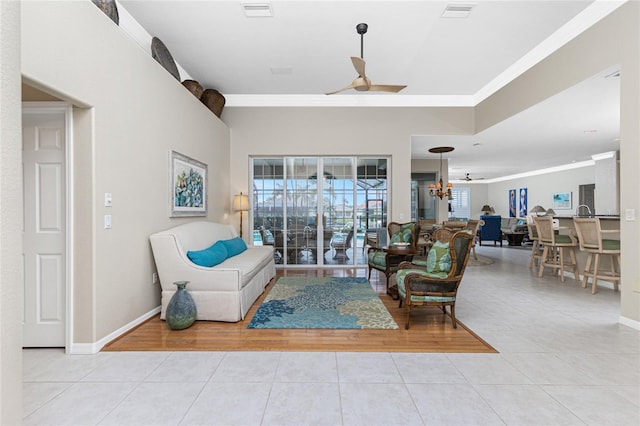 living room featuring crown molding, ceiling fan with notable chandelier, and light tile patterned floors