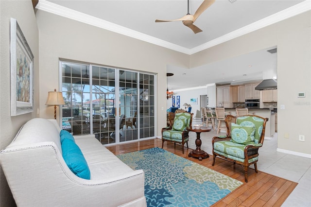 living room featuring ornamental molding, light hardwood / wood-style floors, and ceiling fan