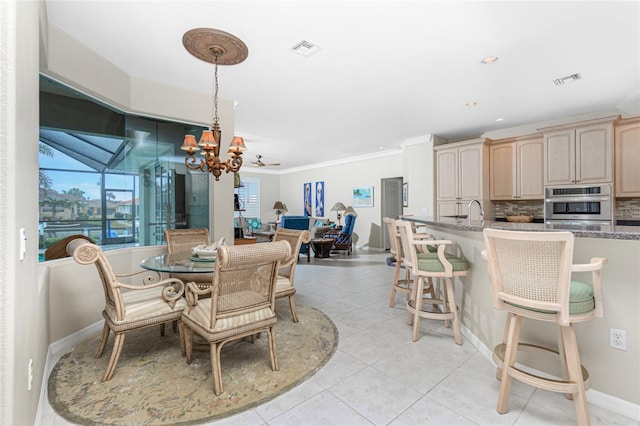 dining room featuring light tile patterned floors, a notable chandelier, ornamental molding, and sink