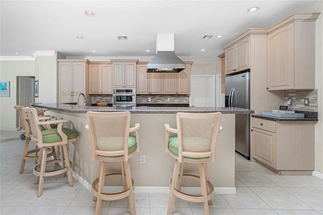 kitchen with island range hood, a center island with sink, stainless steel appliances, and light brown cabinets