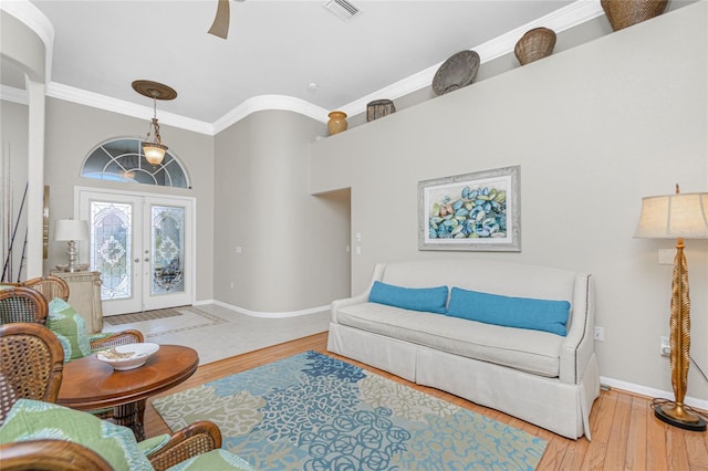 living room featuring hardwood / wood-style floors, crown molding, french doors, and ceiling fan