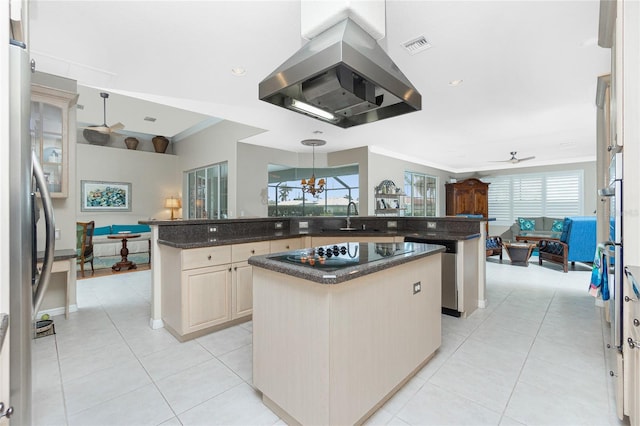 kitchen with island exhaust hood, dark stone counters, decorative light fixtures, and a kitchen island