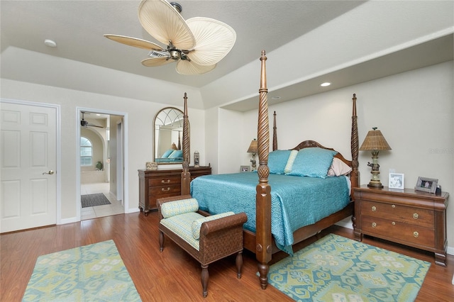 bedroom featuring connected bathroom, hardwood / wood-style floors, and ceiling fan