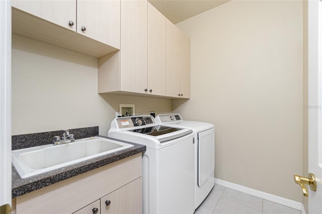 laundry room with cabinets, washing machine and dryer, sink, and light tile patterned floors