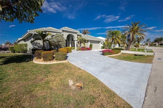 mediterranean / spanish-style house featuring a garage and a front yard