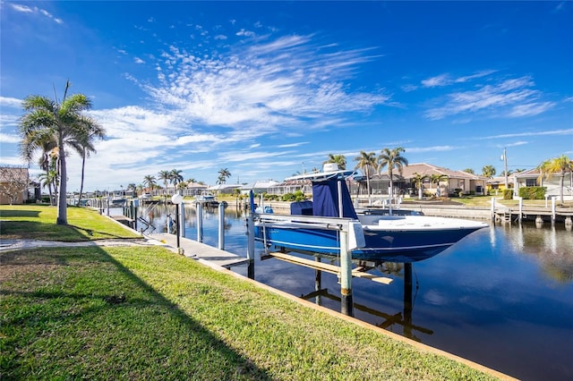 view of dock with a yard and a water view