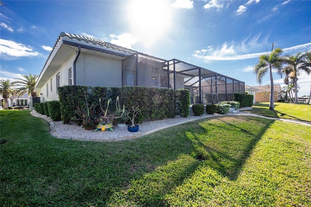 view of property exterior featuring glass enclosure and a lawn