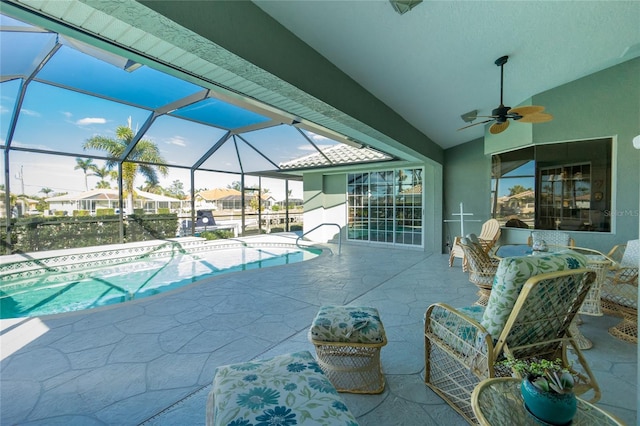 view of pool with ceiling fan, a lanai, and a patio