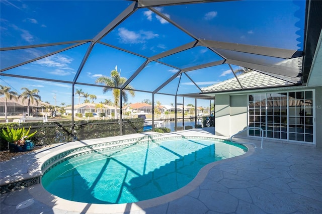 view of swimming pool with a patio, a water view, and glass enclosure