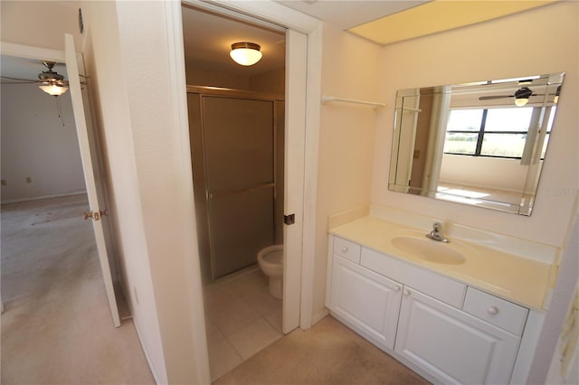 bathroom featuring walk in shower, tile patterned floors, toilet, vanity, and ceiling fan