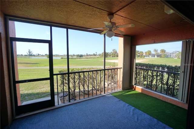 unfurnished sunroom featuring ceiling fan