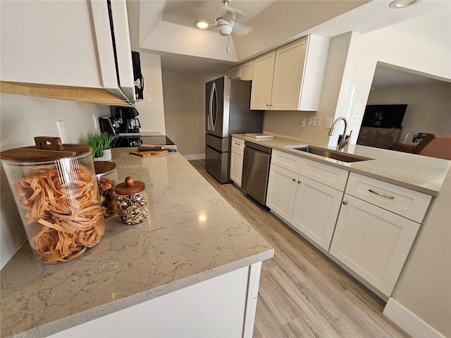 kitchen featuring appliances with stainless steel finishes, sink, white cabinets, and light stone counters