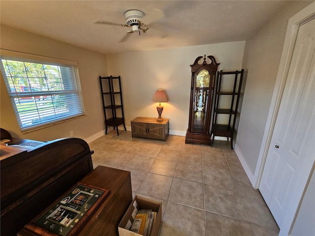 living area featuring light tile patterned floors and ceiling fan