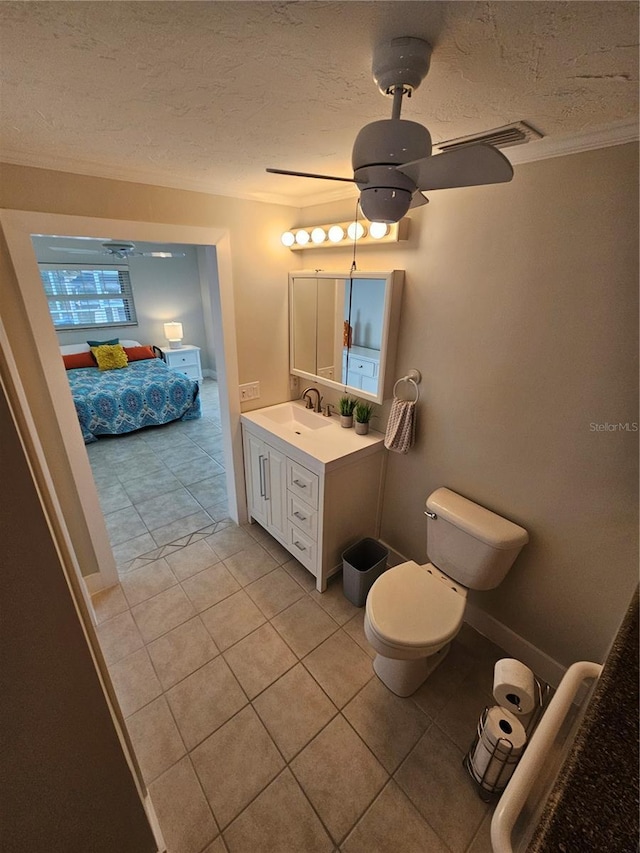 bathroom with ceiling fan, vanity, a textured ceiling, tile patterned floors, and toilet