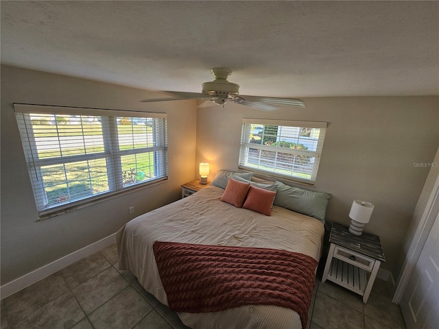 tiled bedroom with multiple windows and ceiling fan