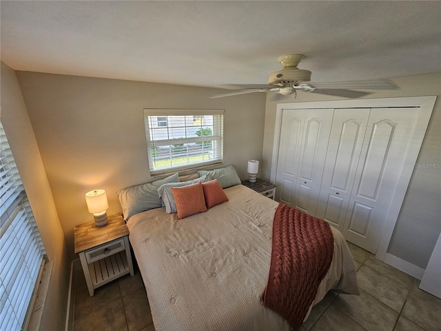 tiled bedroom with ceiling fan and a closet