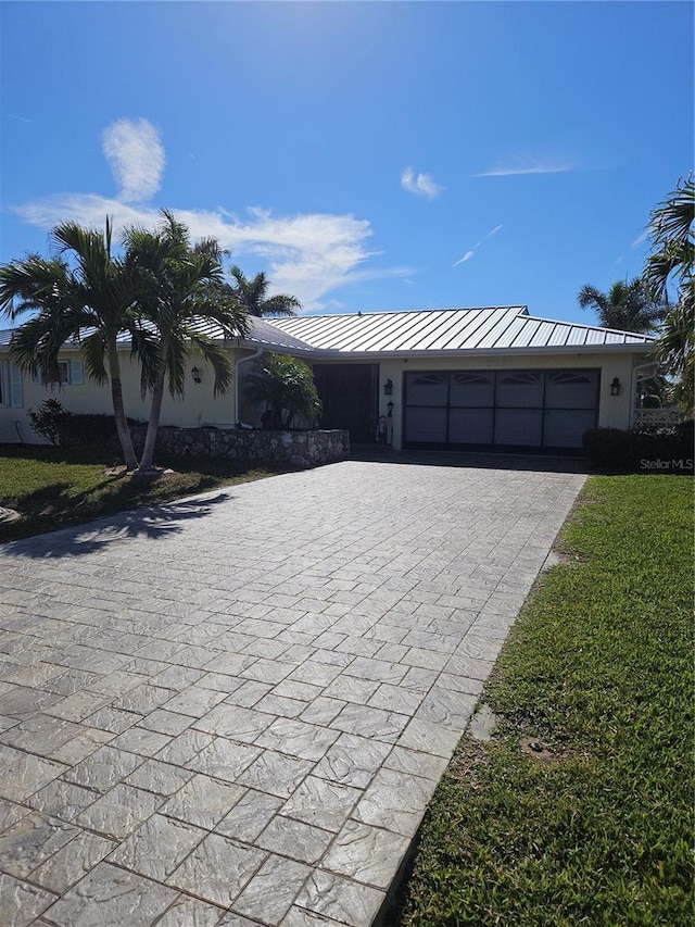 view of front of home with a garage and a front lawn