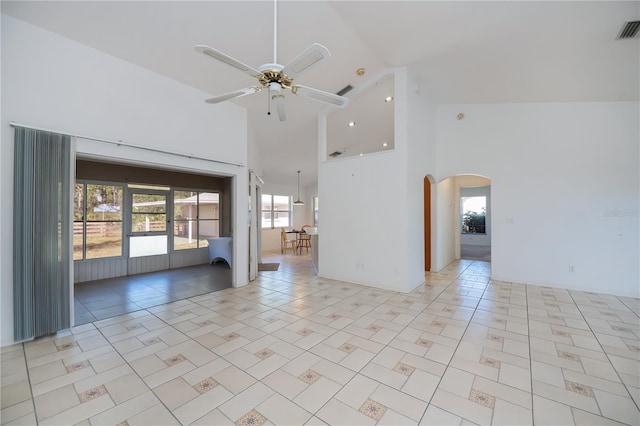 tiled spare room with ceiling fan and high vaulted ceiling