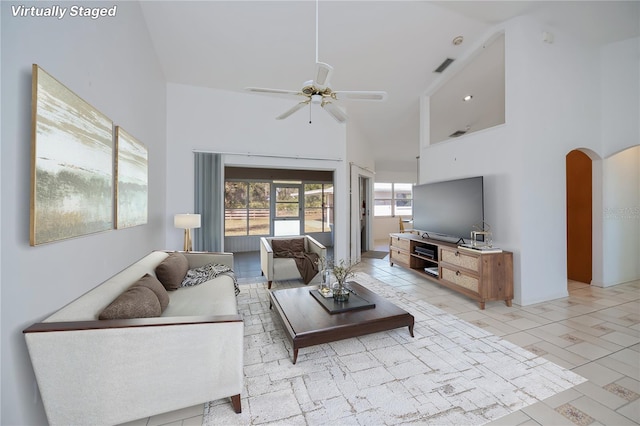 living room with ceiling fan and a high ceiling