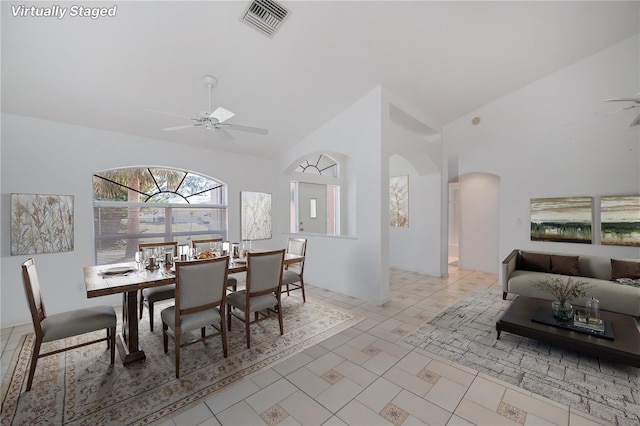 dining area with high vaulted ceiling and ceiling fan