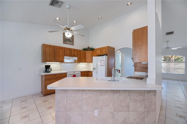 kitchen featuring sink, white fridge with ice dispenser, kitchen peninsula, and ceiling fan