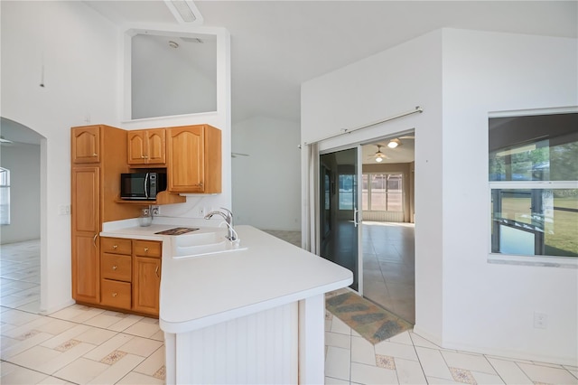 kitchen with sink, a towering ceiling, and ceiling fan