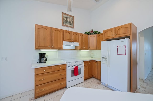 kitchen featuring white appliances, high vaulted ceiling, and decorative backsplash