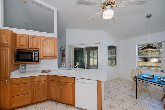 kitchen featuring sink, decorative light fixtures, vaulted ceiling, white dishwasher, and a wealth of natural light