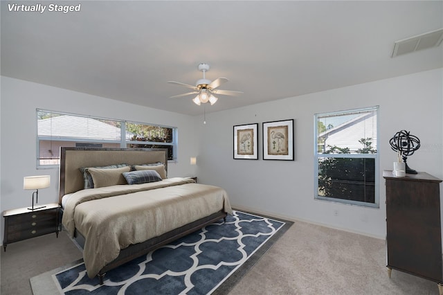 carpeted bedroom with ceiling fan and multiple windows