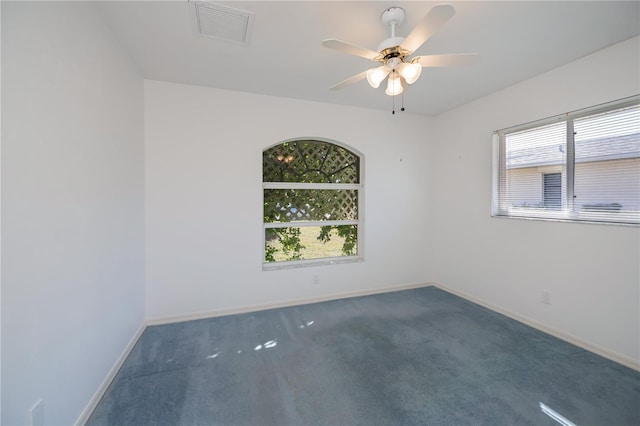 carpeted spare room featuring plenty of natural light and ceiling fan