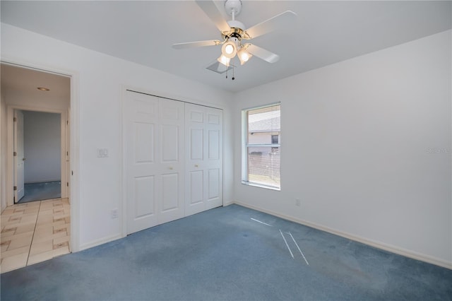 unfurnished bedroom with ceiling fan, carpet floors, and a closet