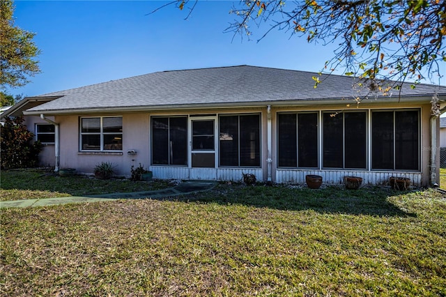 rear view of property featuring a lawn