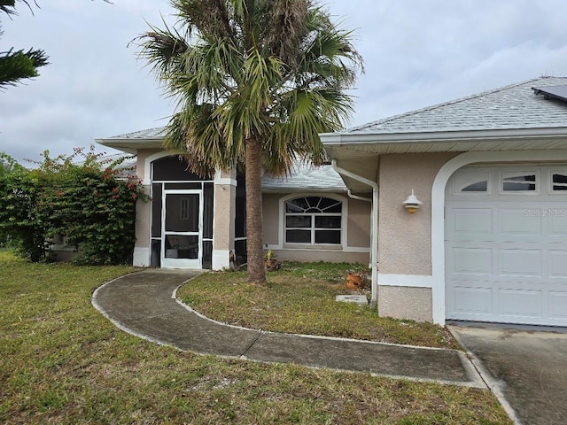 property entrance featuring a garage and a lawn