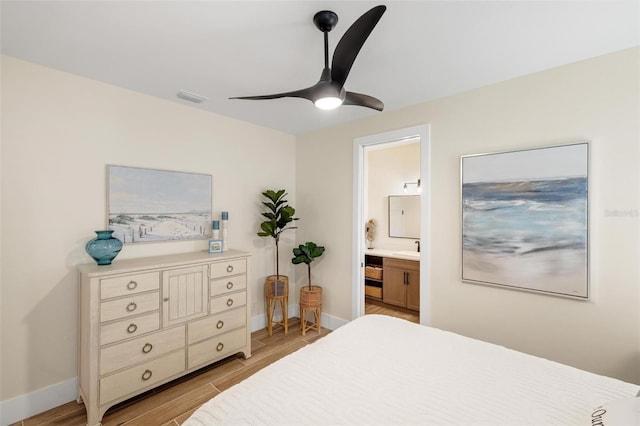 bedroom featuring ensuite bath, light hardwood / wood-style floors, and ceiling fan