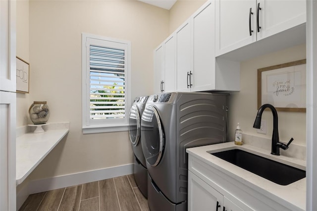 washroom with cabinets, separate washer and dryer, and sink